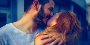 man kissing woman on forehead