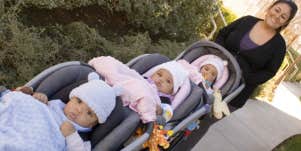 woman pushing triplet babies in a stroller