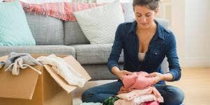 woman packing clothes in a box