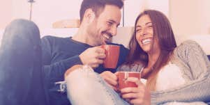 couple smiling at each other, sitting on couch