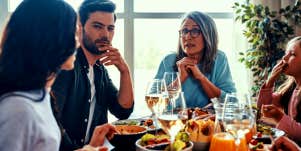 family sitting around table with mother-in-law who doesn't like daughter-in-law