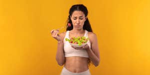woman eating a salad, not liking it
