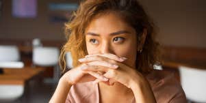 woman with hands clasped looking distraught