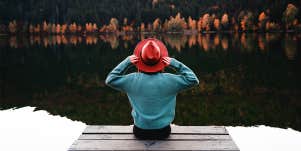 woman sitting on dock by river