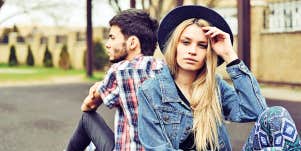 Woman and man sit back to back ignoring each other