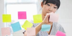 woman writing on post it notes