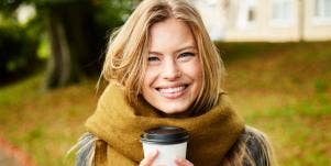 smiling woman holding a coffee cup