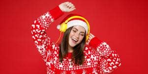 woman dancing in christmas sweater and headphones