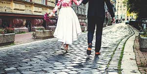 man and woman walking away on cobblestones