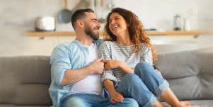 couple, smiling at each other, sitting on the couch