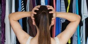 frustrated woman with hands on head in front of clothing in closet