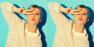 woman with peace sign in front of face