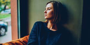 woman looks out window