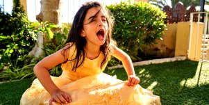little girl in yellow dress throwing a tantrum