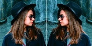 mirrored image of perfectionist woman in a hat
