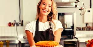 woman holding a pie smiling for Pi Day