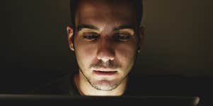 man watching video on laptop at night