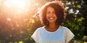 Confident, relaxed woman smiles outside