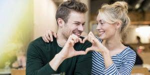 man and woman making heart with their hands