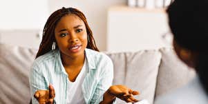 concerned Black woman shrugs, talking to a Black woman therapist
