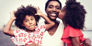 glowing happy Black mom with two young daughters