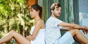 man and woman sitting with backs to each other