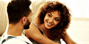 woman with natural curly hair smiles at a man