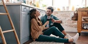 couple talking on the floor of a kitchen