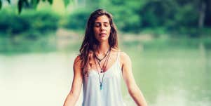 Woman praying by a lake