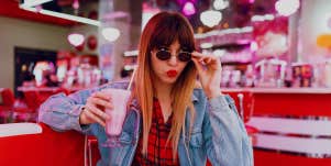 woman in diner drinking milkshake