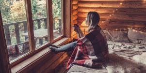 woman sitting on the bed looking out the window