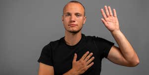 man swearing to tell the truth with hand on heart
