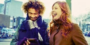 biracial couple smiling, walking down the street 