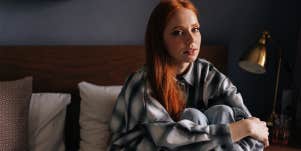 unhappy girl sitting alone on her bed