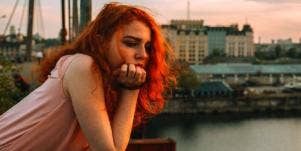 Woman with her head in her hand looking down and sad