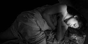 sad woman laying in bed