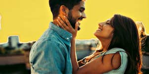young couple looking at each other in front of yellow sky, city scape