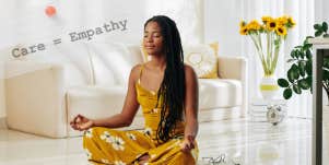 Black woman with long hair meditates on her value in a white living room