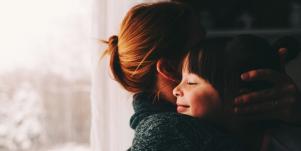 woman hugging little girl