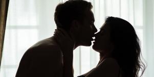 man and woman in shadow kissing