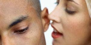 woman whispering in man's ear