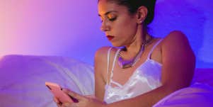 woman in nightgown texting from bed