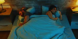couple sharing bed unable to sleep