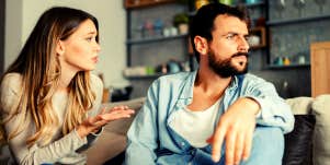 woman apologizing to her boyfriend while sitting on the couch