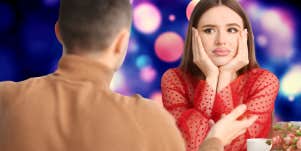 woman with chin cradled in her hands looking exasperated across the table while on a date