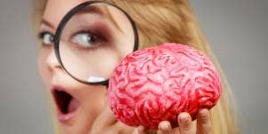 woman look at brain through magnifying glass
