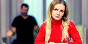 upset woman with controlling man behind her