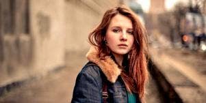 sad woman looking forward red hair jean jacket