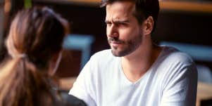 man looking unsure while he talks to a woman over coffee
