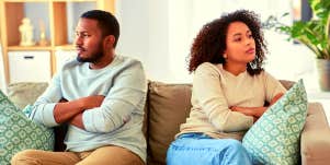 unhappy couple sitting on couch looking away from each other